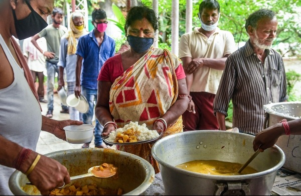 Volunteers handing dry ration packets to villagers